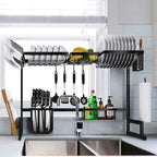 Black adjustable rack arranged over a sink; tableware and cleaning supplies are props