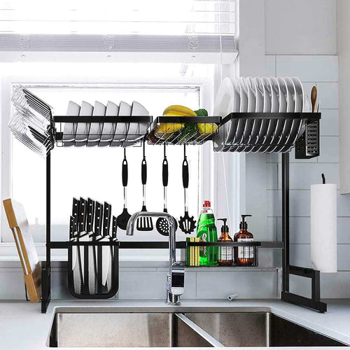 Black adjustable rack arranged over a sink; tableware and cleaning supplies are props